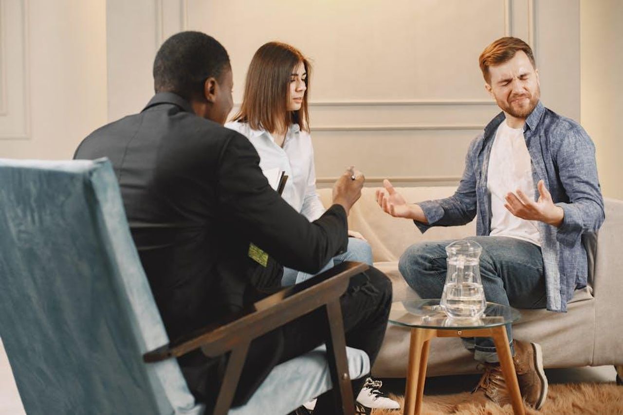 2024_un_anno_di_sfide_legali_l5RrEbGZJg - Veicoli24 Source: Gustavo Fring - pexels - A diverse couple in a serious conversation with a lawyer during a meeting in an office setting.