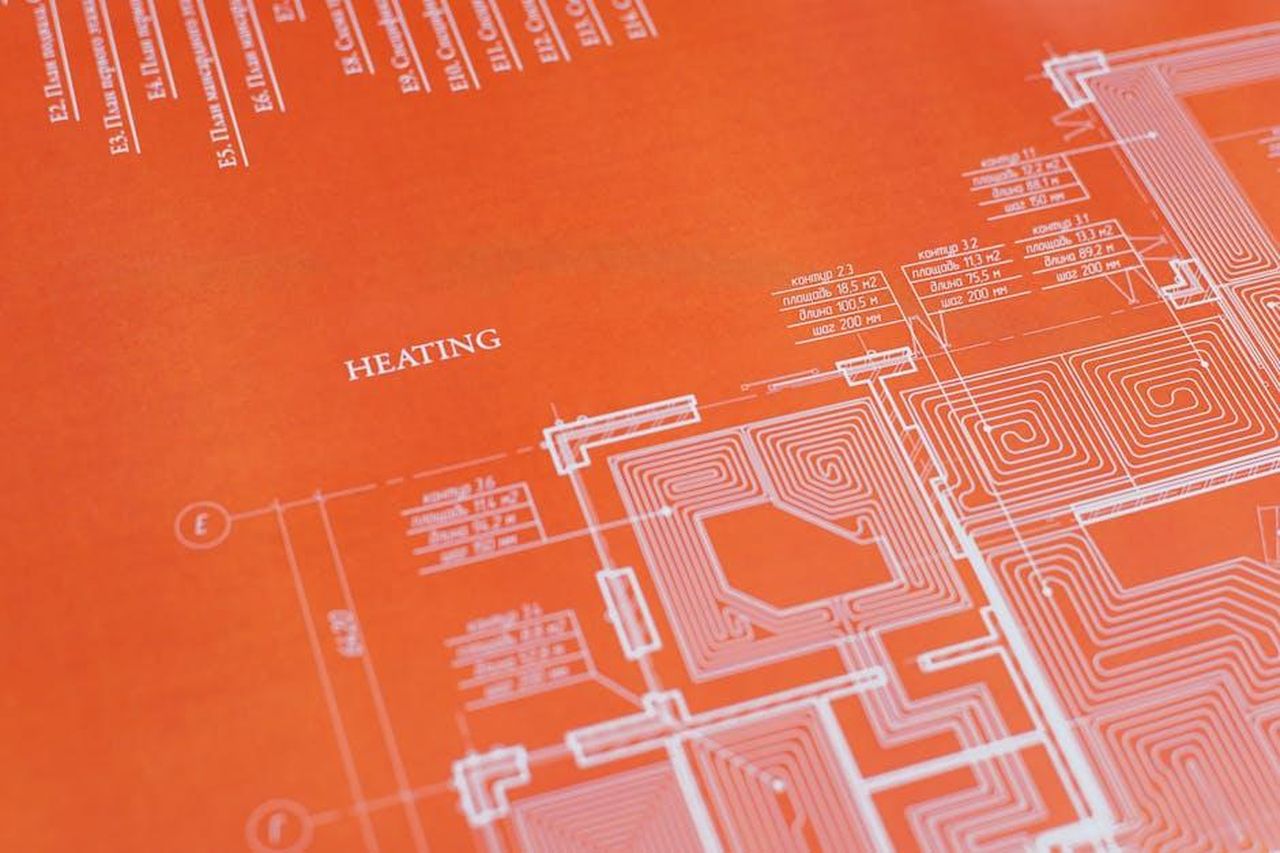Allegati_dellarticolo_offline_EW8uwHWmEx - Veicoli24 Source: Ivan Samkov - pexels - Close-up of an orange architectural heating blueprint showing intricate design details.