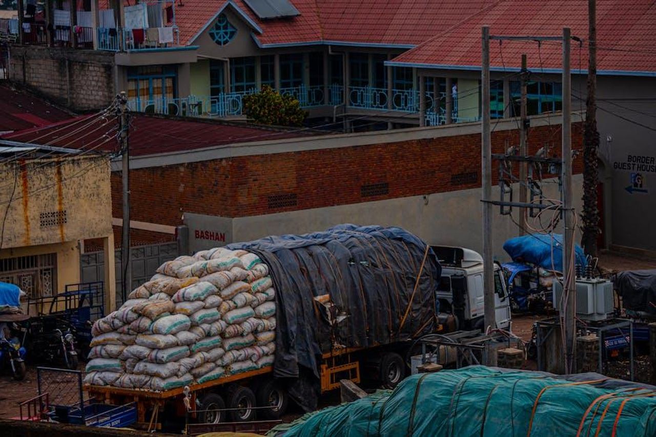 Altri_produttori_di_veicoli_elettrici_nel_2024_5evspIq9XT - Veicoli24 Source: Mad Knoxx Deluxe - pexels - A cargo truck loaded with sacks parked in an urban area near a guest house.