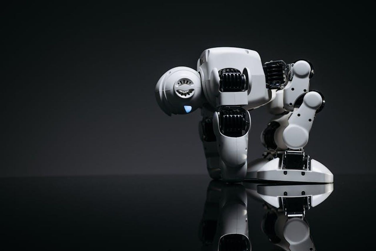 Altri_produttori_e_il_futuro_dei_motori_V8_apaC4obTbw - Veicoli24 Source: Pavel Danilyuk - pexels - A modern robot toy depicted in a studio environment with its reflection visible on a dark surface.
