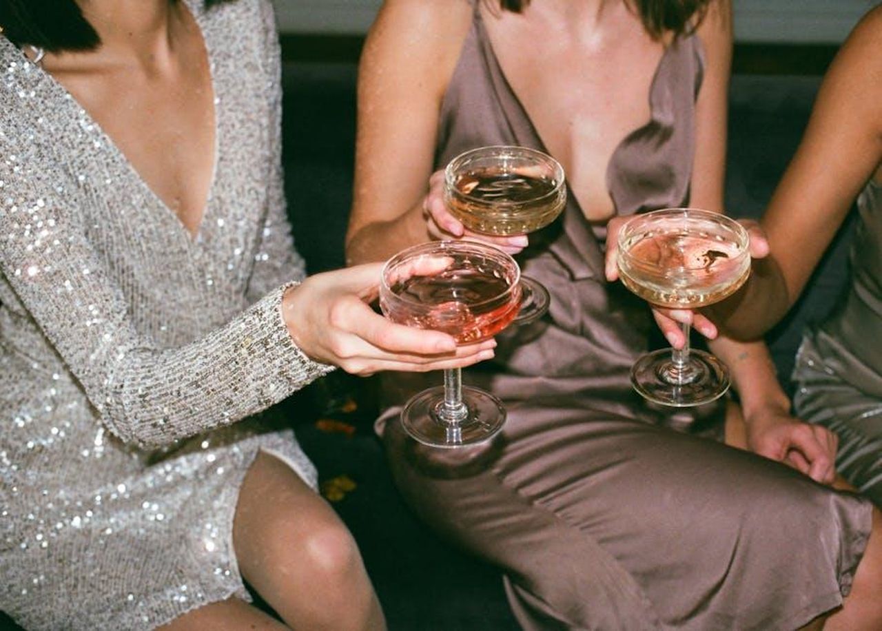 Analisi_delle_vendite_di_dicembre_2024_poi6nGbB1y - Veicoli24 Source: Inga Seliverstova - pexels - Three women in stylish dresses toasting with champagne at a festive gathering.