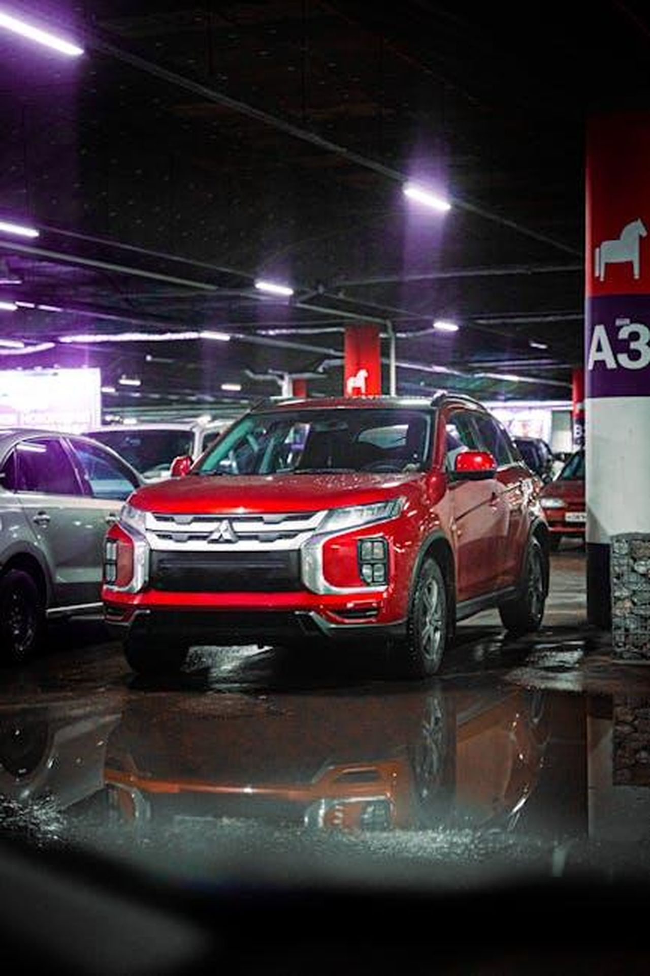 Annuncio_del_SUV_di_medie_dimensioni_e_tempistiche_di_produzione_Sces8doQZs - Veicoli24 Source: Alex Urezkov - pexels - Red SUV parked in an underground garage with reflections on the wet floor.