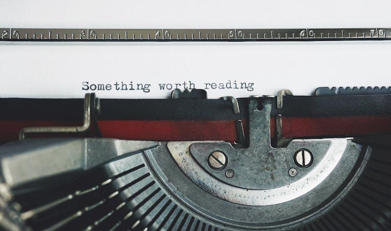 Autore_ZO5d9doNKH - Veicoli24 Source: Suzy Hazelwood - pexels - Close-up of a vintage typewriter with the phrase 'Something worth reading'.