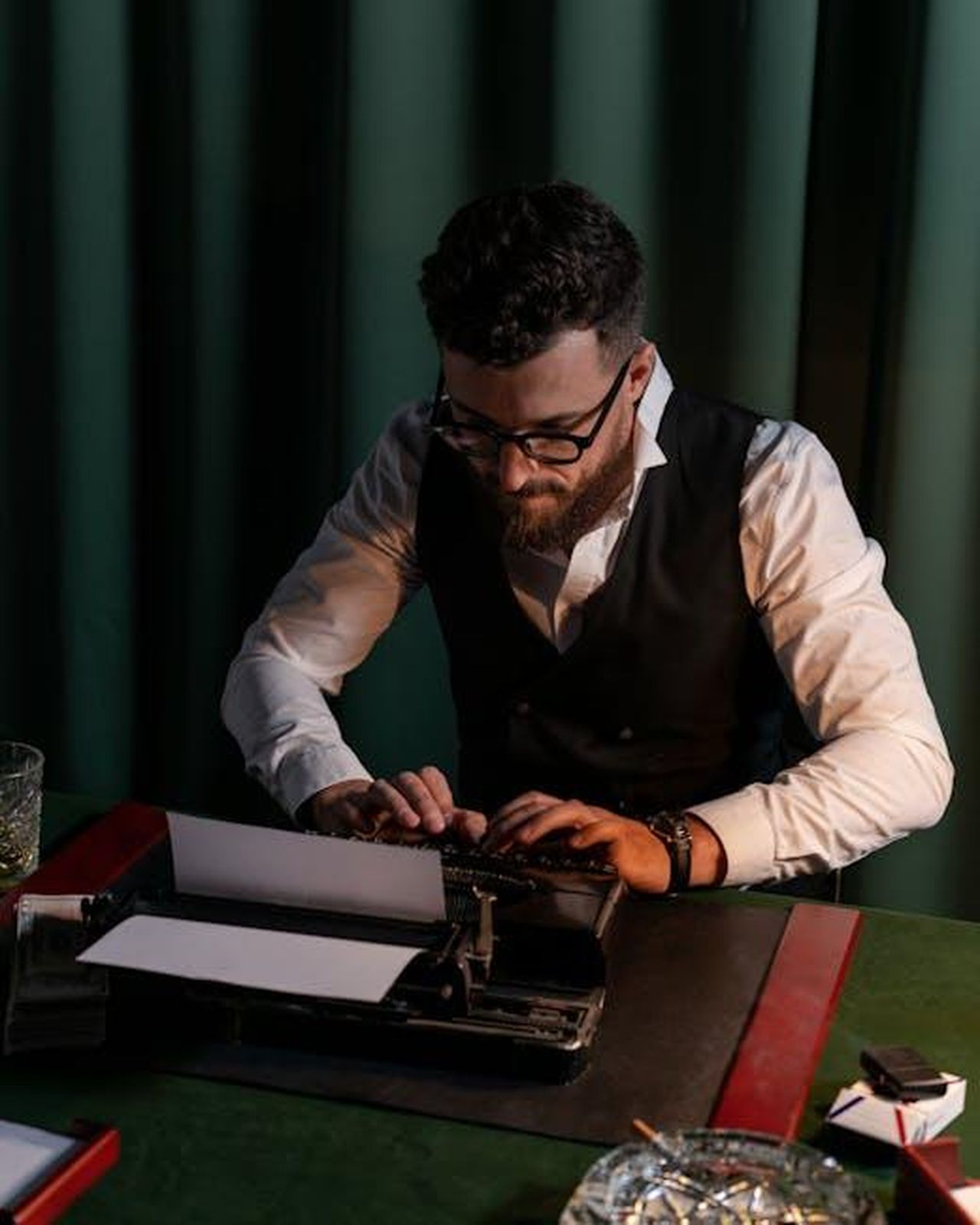 Autore_dellarticolo_DoinHsmyJt - Veicoli24 Source: cottonbro studio - pexels - Man intently typing on a vintage typewriter in a dimly lit room, capturing a nostalgic workplace scene.