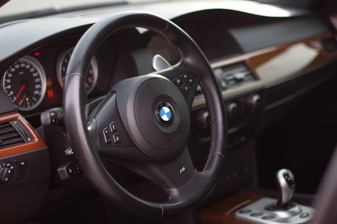 BMW_e_MercedesBenz_risultati_e_posizioni_WALNb9OAyn - Veicoli24 Source: Kateryna Babaieva - pexels - Close-up view of a BMW car interior with focus on the steering wheel and dashboard.