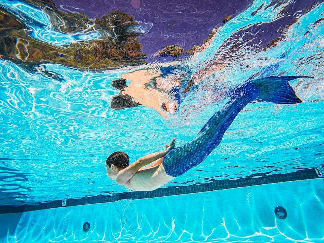 BYD_e_la_creazione_di_un_pool_di_emissioni_2Gqm0pmR9O - Veicoli24 Source: Kindel Media - pexels - A person with a mermaid tail swims underwater in a pool, creating a magical scene.