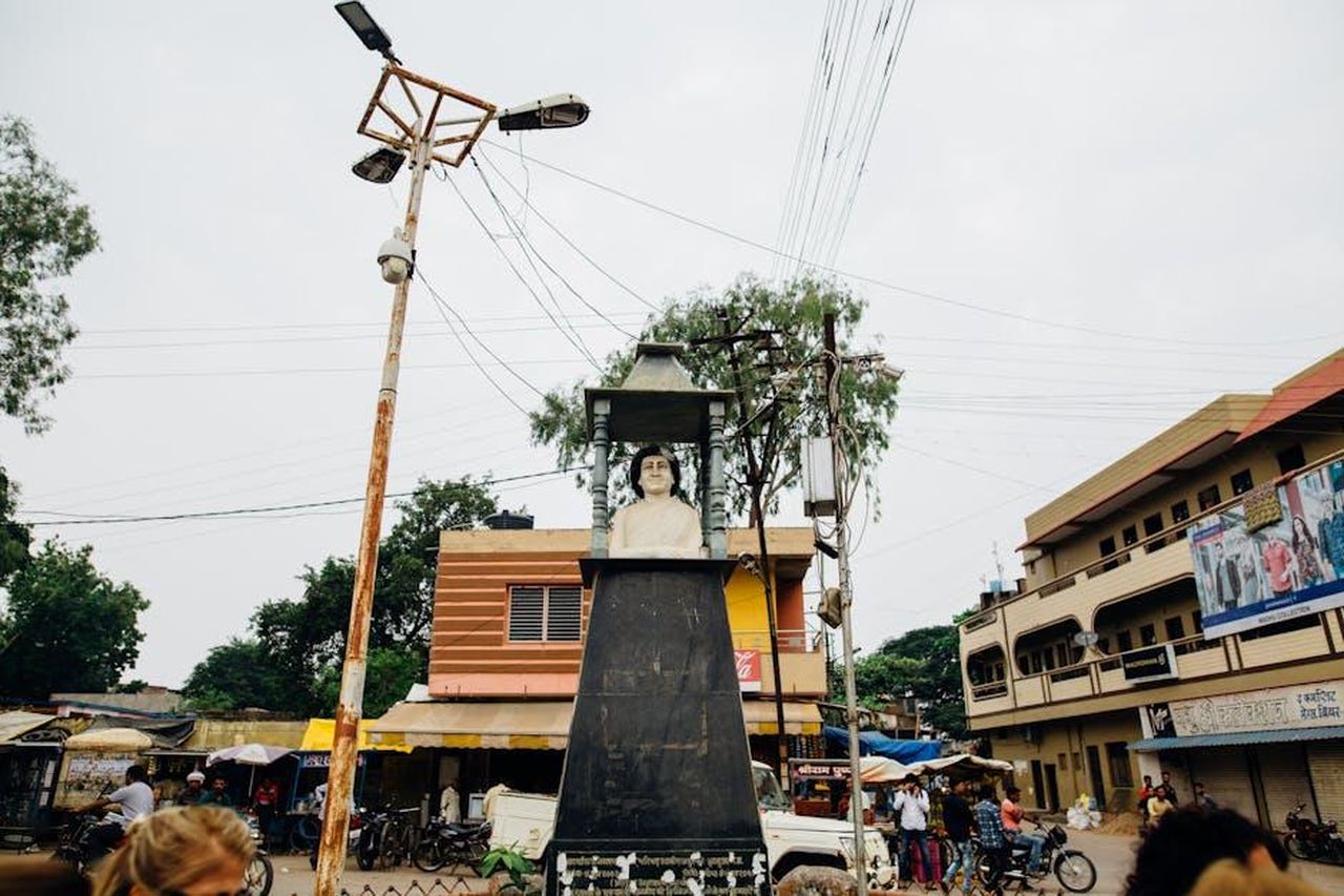 BYD_il_leader_del_mercato_EV_in_Cina_C5vinIRzGH - Veicoli24 Source: Kelly - pexels - Street view of a bust sculpture in an Indian town square, surrounded by buildings and people.