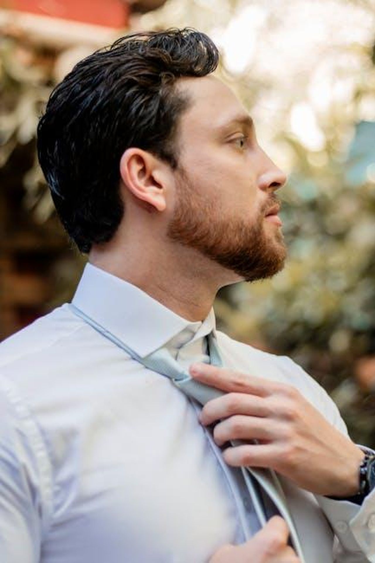 Cambiamenti_nella_leadership_di_Stellantis_nKxr1vatWp - Veicoli24 Source: Vinicius Quaresma - pexels - Side profile of a businessman adjusting his tie, captured outdoors, exuding confidence.