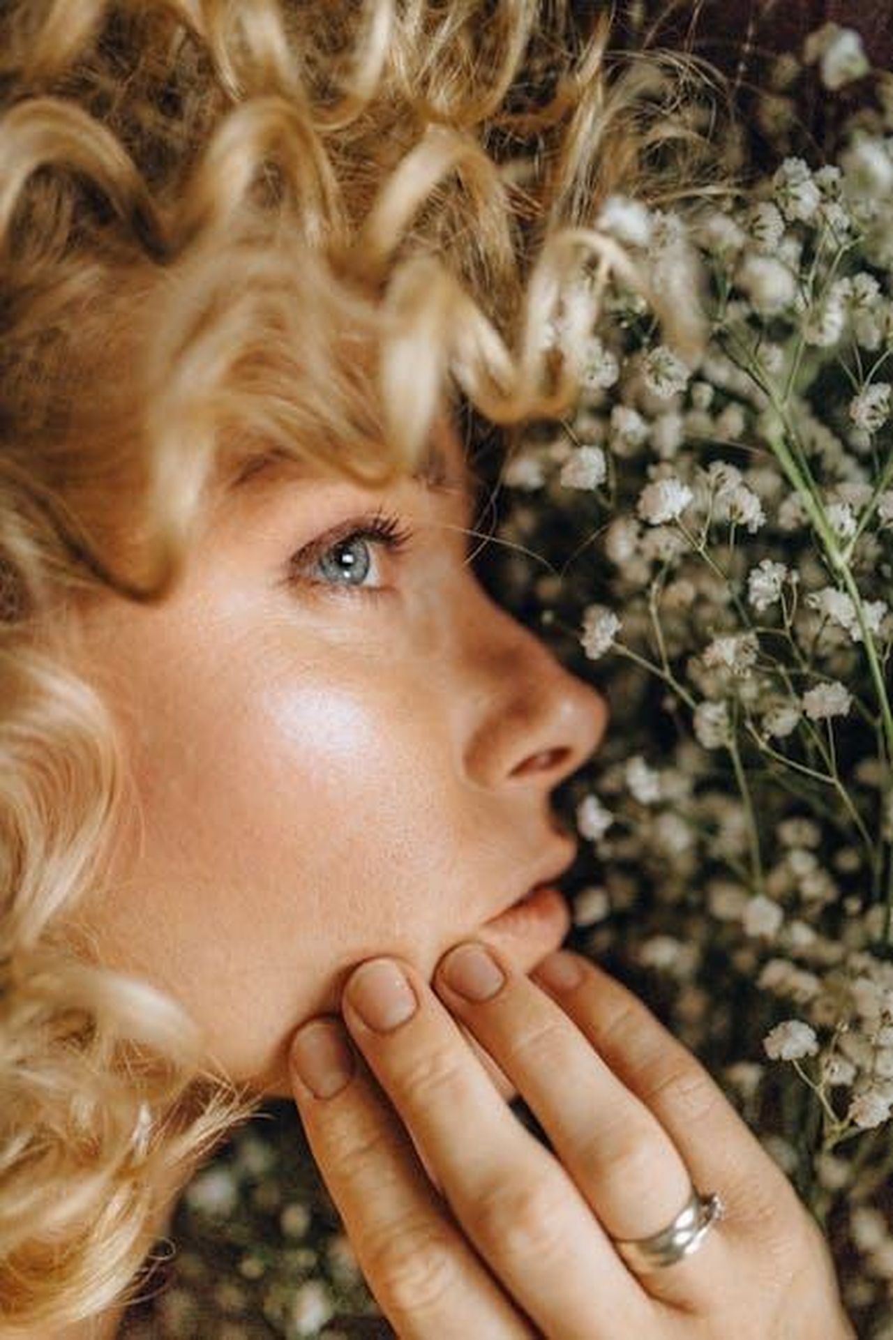 Caratteristiche_del_GMC_Yukon_2025_BNjQRp2CJ5 - Veicoli24 Source: Nataliya Vaitkevich - pexels - A detailed portrait showcasing a woman's face amid white flowers and curls, highlighting her serene expression.