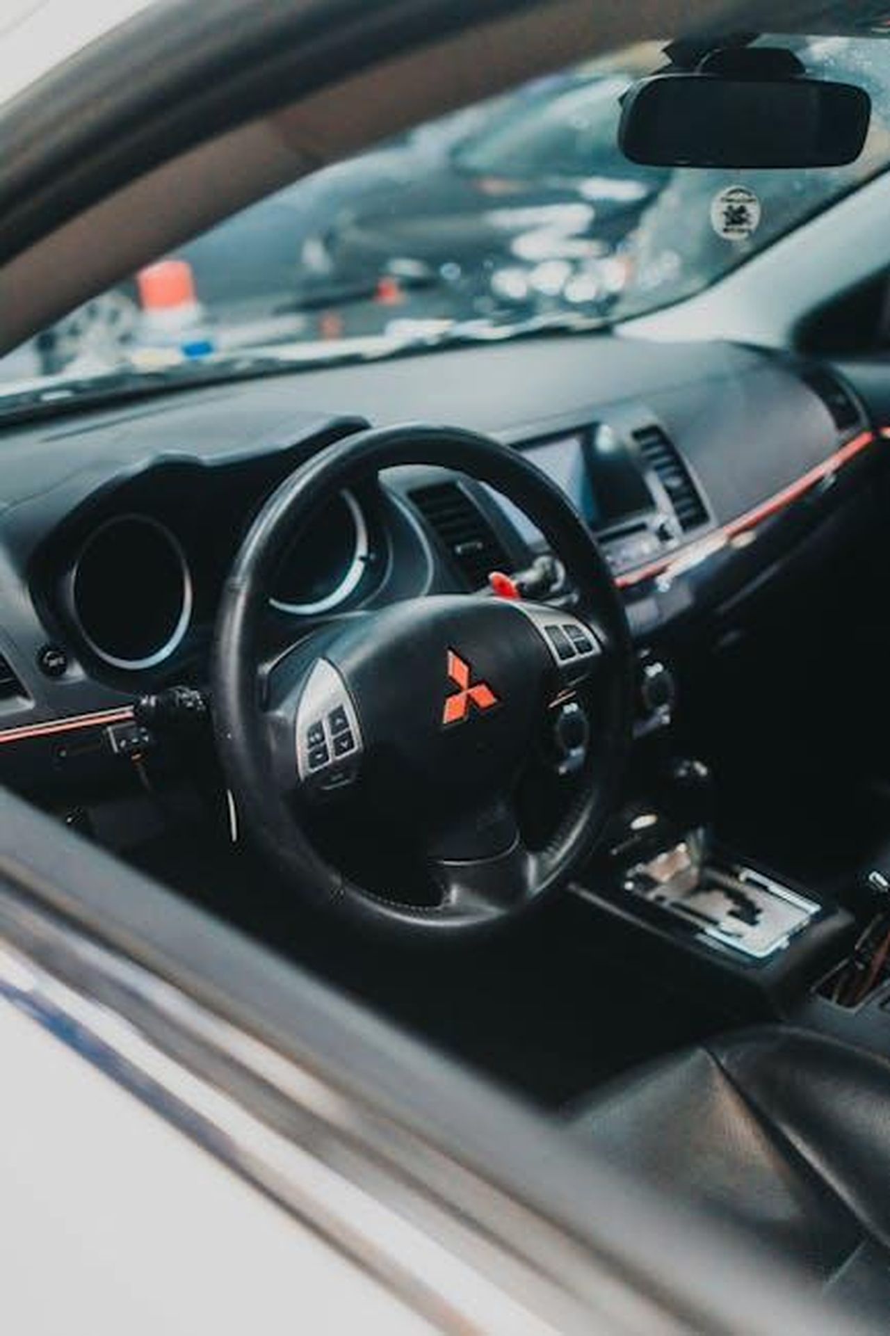 Caratteristiche_della_Mitsubishi_Outlander_2025_jTk1Mz60R6 - Veicoli24 Source: Matheus Bertelli - pexels - Close-up of a Mitsubishi car's dashboard and steering wheel, showcasing the interior design.