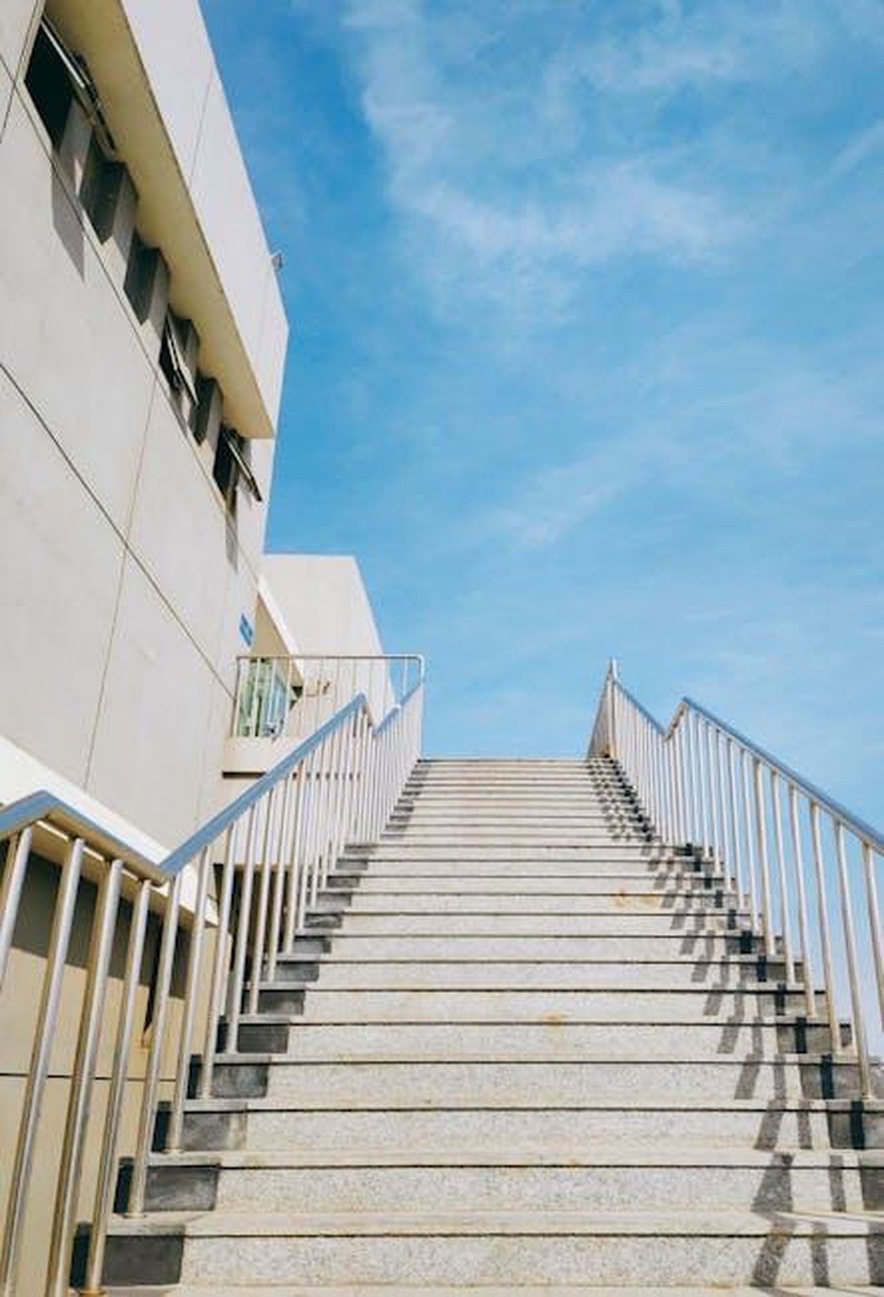 Caratteristiche_della_Subaru_Ascent_2025_MnZPxTWwYe - Veicoli24 Source: Siriss - pexels - A modern staircase with metal handrails leading up to a blue sky, showcasing urban architecture.
