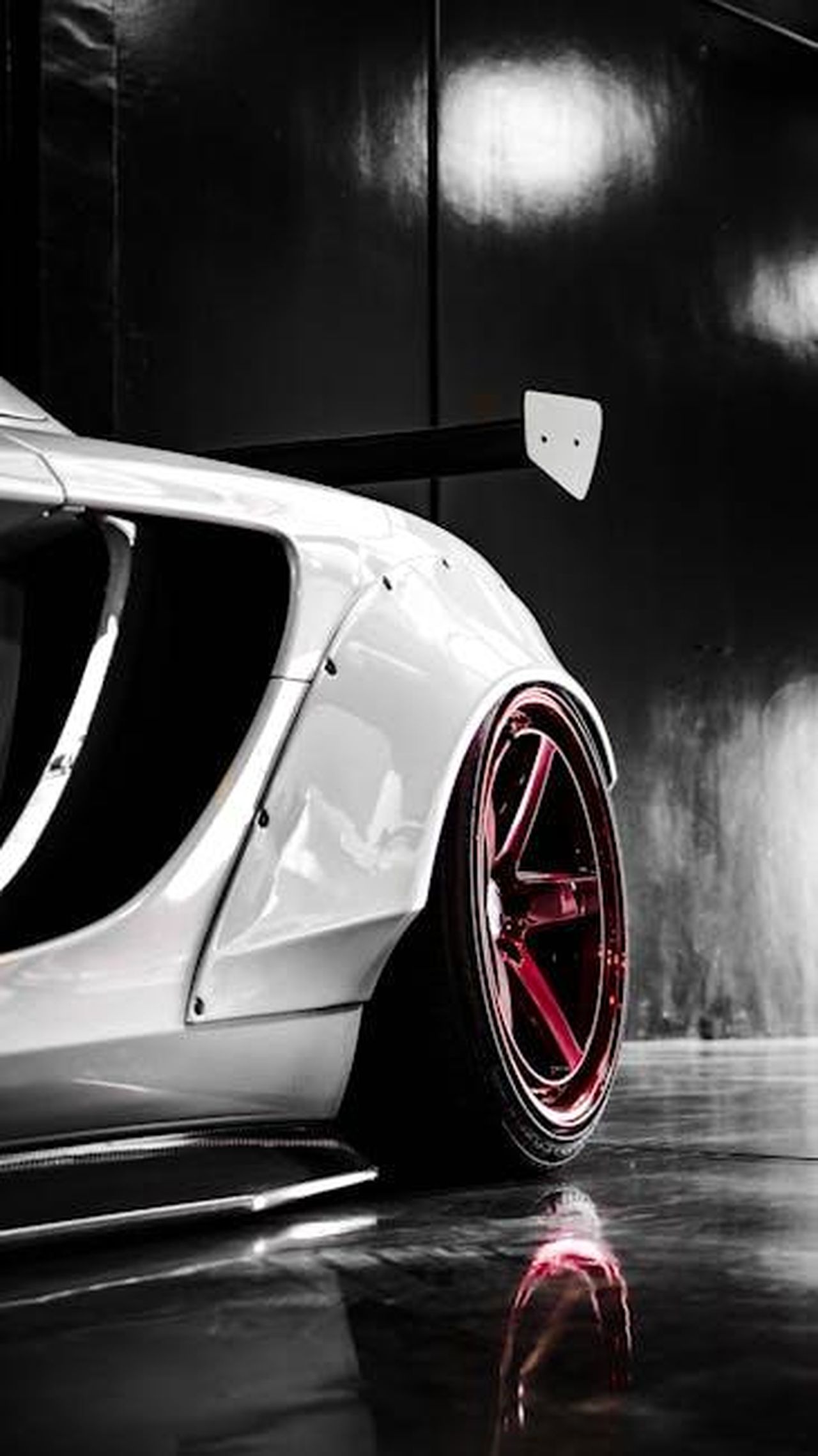 Caratteristiche_delle_edizioni_speciali_6ApGDhCiIk - Veicoli24 Source: jae p - pexels - Close-up of a modern sports car showcasing sleek red rims and aerodynamic design.