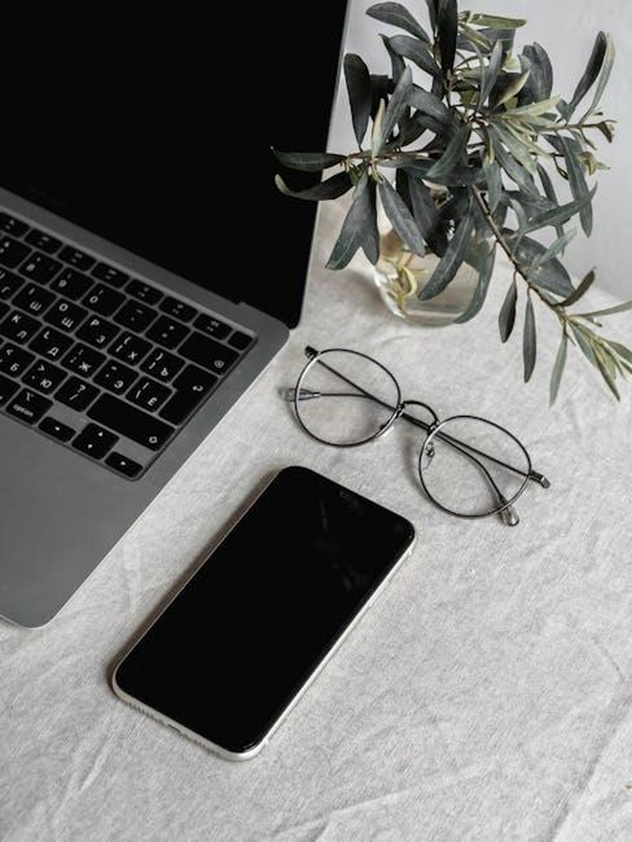 Caratteristiche_e_specifiche_della_Cadillac_CT5_2025_Jqra0eEOXO - Veicoli24 Source: Polina ⠀ - pexels - Flat lay of a laptop, smartphone, glasses, and plant on a table.