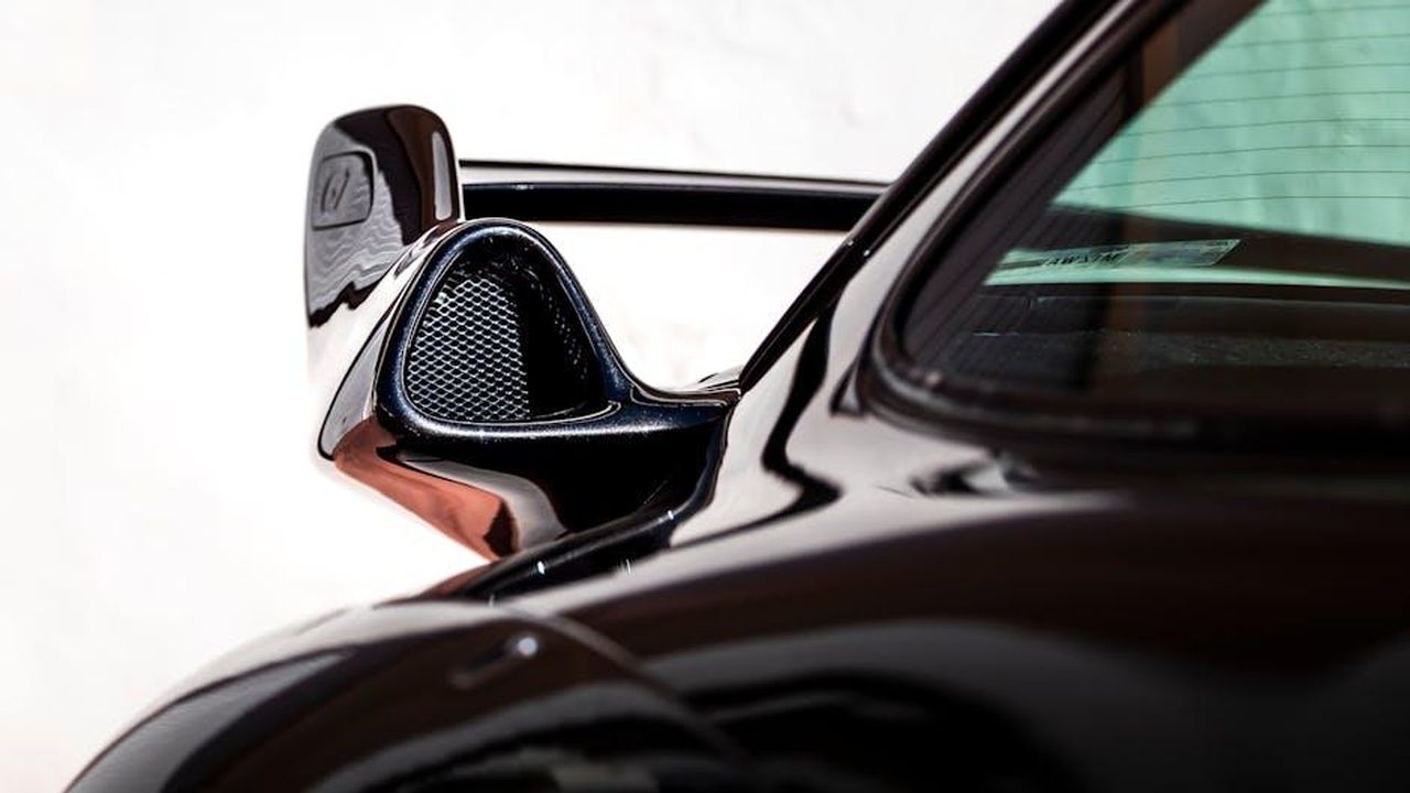 Caratteristiche_esYkIyn45f - Veicoli24 Source: Quentin Martinez - pexels - Detailed view of a luxury car's aerodynamic vent on a sleek black body.