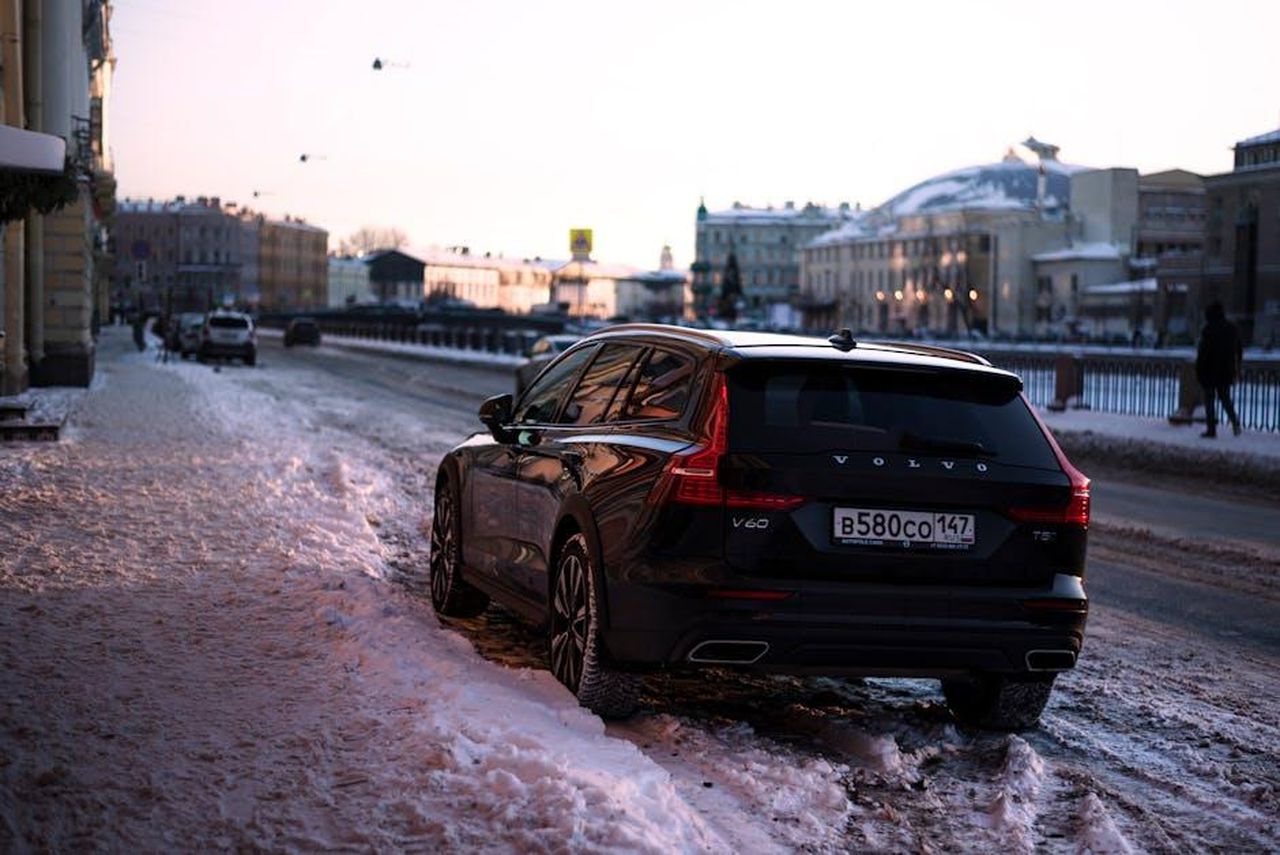 Caratteristiche_tecniche_della_V60_Polestar_Engineered_L7n4P4iu1v - Veicoli24 Source: Vitali Adutskevich - pexels - Black Volvo V60 parked on a snow-covered street in a winter city scene at sunset.
