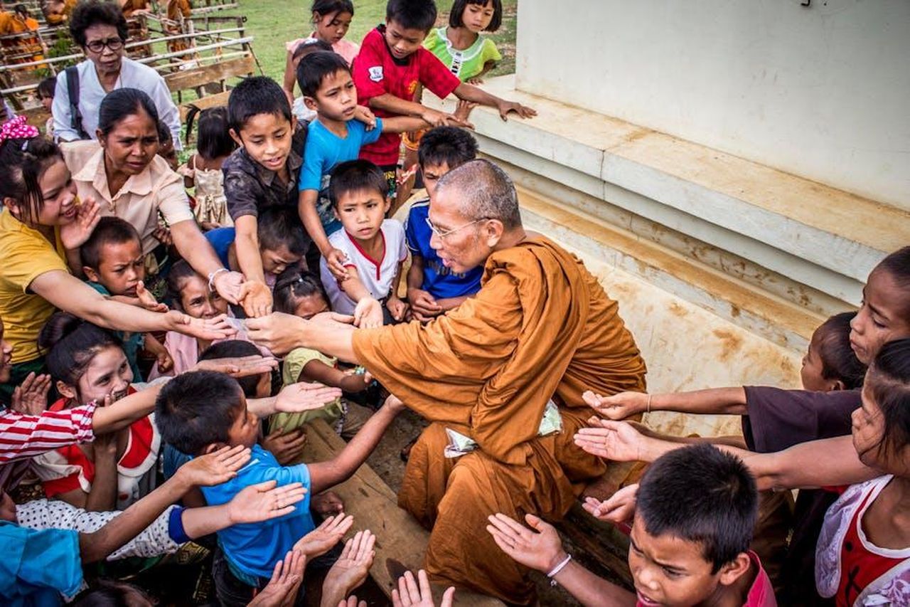 Coach_Core_la_missione_della_charity_jfTsbrS1aU - Veicoli24 Source: Suraphat Nuea-on - pexels - A Buddhist monk sharing gifts with children, capturing a moment of compassion and cultural tradition.