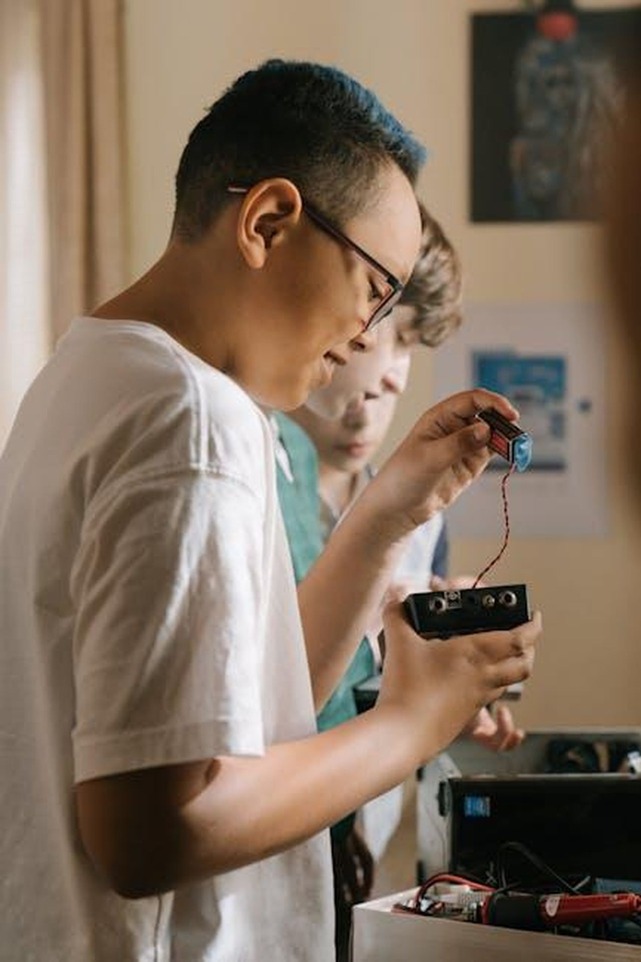 Collaborazione_con_Factorial_K5a7avVxy7 - Veicoli24 Source: cottonbro studio - pexels - Children exploring electronics indoors, working together on a technical project.