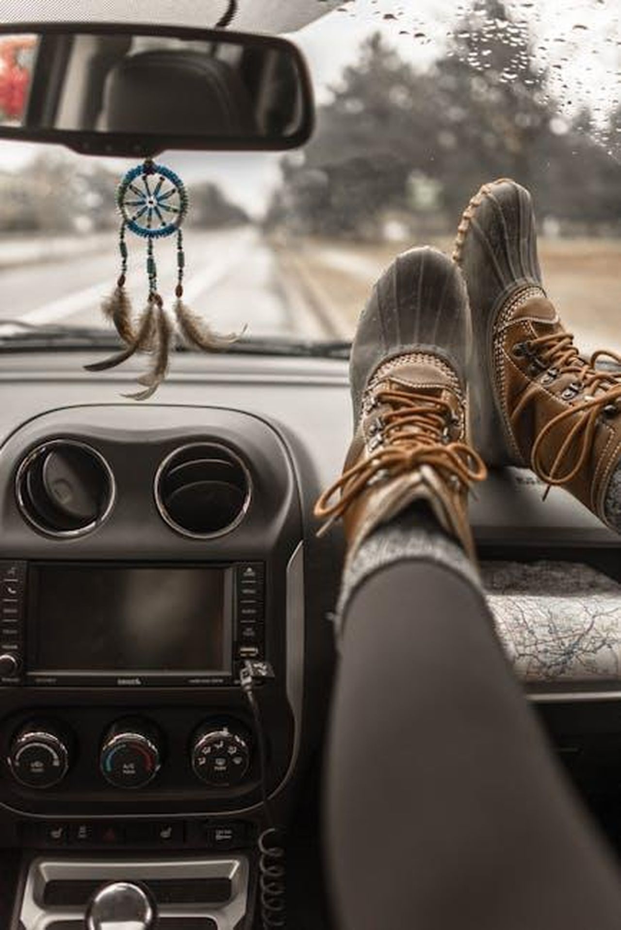 Comfort_e_qualit_ac67q9nziV - Veicoli24 Source: Element5 Digital - pexels - Adventure awaits on a scenic road trip with boots relaxing on a car dashboard.