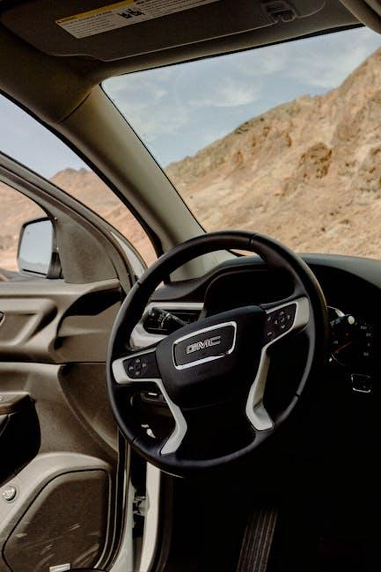Comfort_e_qualit_della_GClass_2024_JgT2MBZL2h - Veicoli24 Source: Wendy Wei - pexels - Explore the elegant interior of a GMC vehicle with a stunning mountain backdrop.