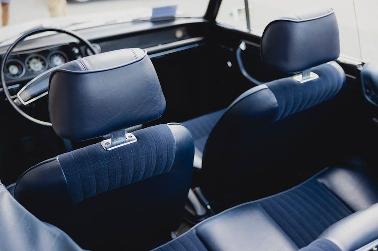 Comfort_e_qualit_pKGPZ2cyi7 - Veicoli24 Source: Markus Spiske - pexels - Close-up of vintage car cockpit with blue leather interior and chrome steering wheel.
