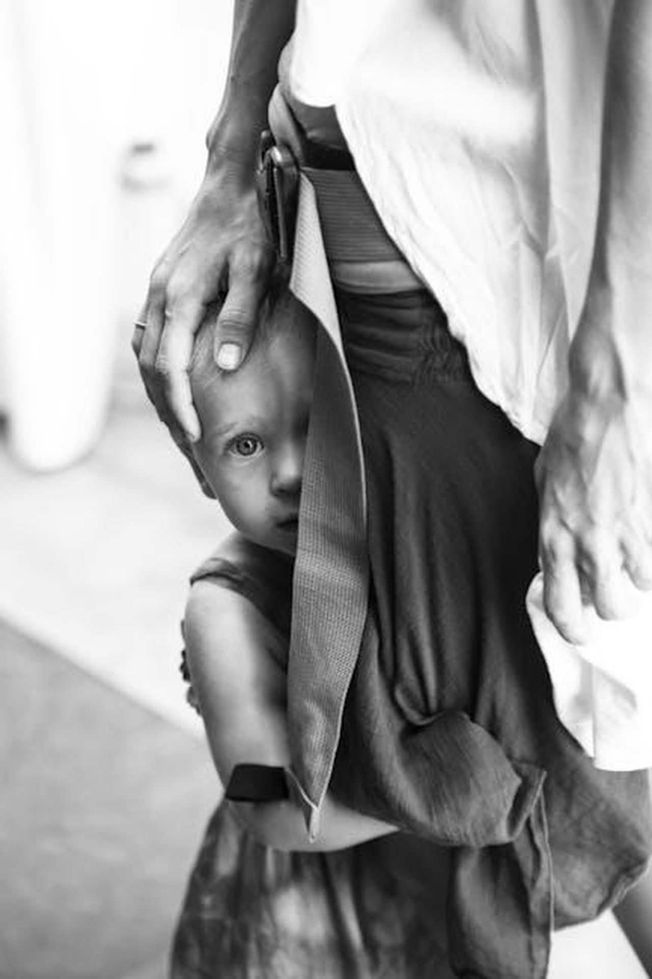 Comprendi_lo_stato_di_vulnerabilit_di_ogni_cliente_cZp5viT81u - Veicoli24 Source: Nikolay Kritskiy - pexels - A young child seeks comfort by clinging to an adult's leg, displaying trust and attachment.