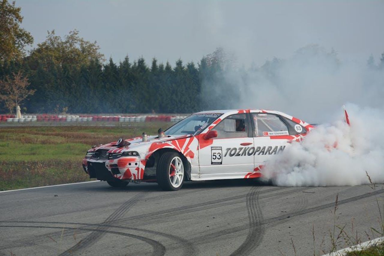 Conclusione_del_Prologo_e_attesa_per_la_gara_UFBVHK49Ef - Veicoli24 Source: Emre TAMTÜRK - pexels - A race car performing an impressive drift on a track, surrounded by smoke.