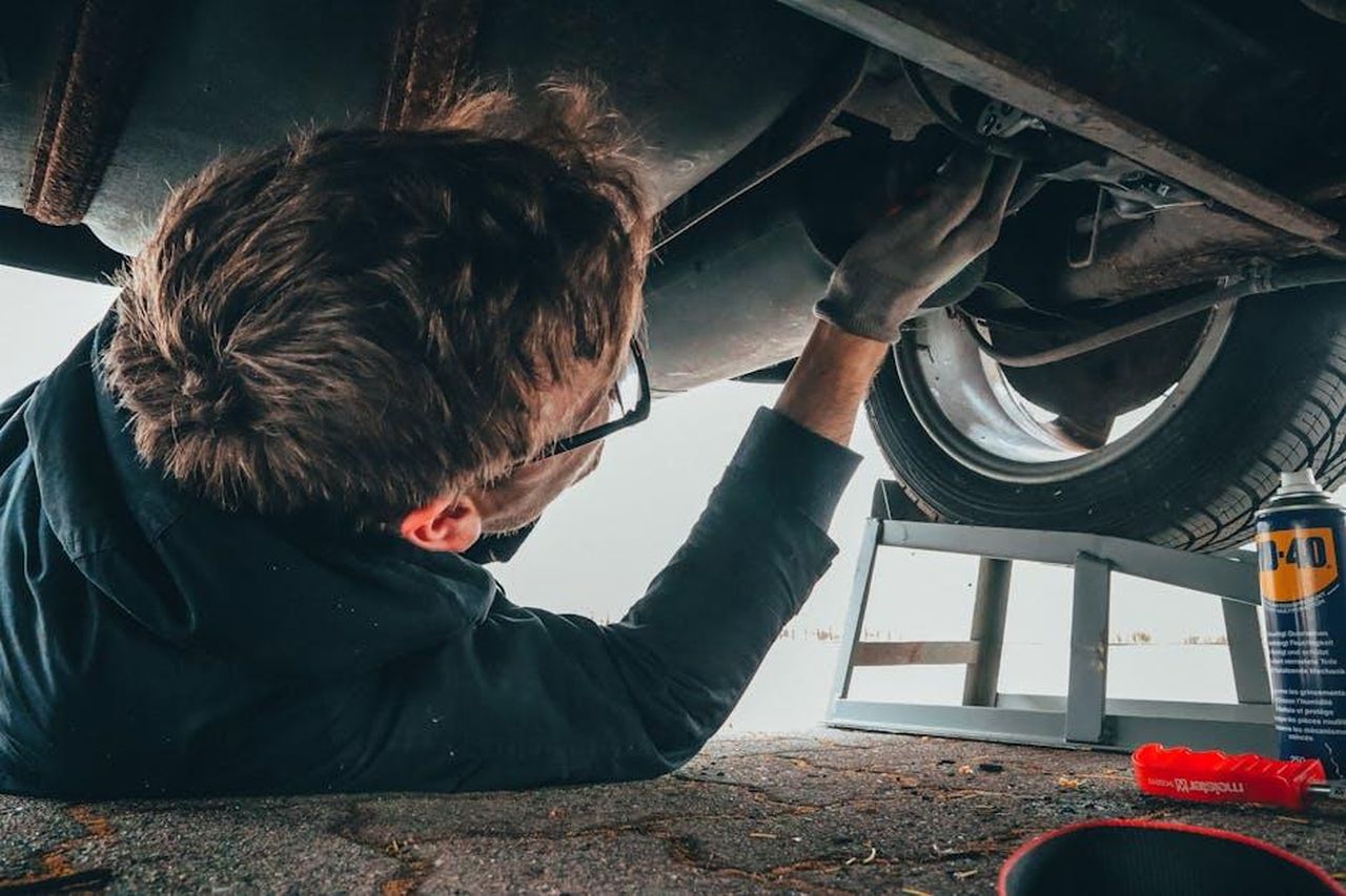 Conclusioni_sul_valore_delle_auto_KTjCHYI1eE - Veicoli24 Source: Malte Luk - pexels - Mechanic skillfully repairing car undercarriage in outdoor setting with tools.