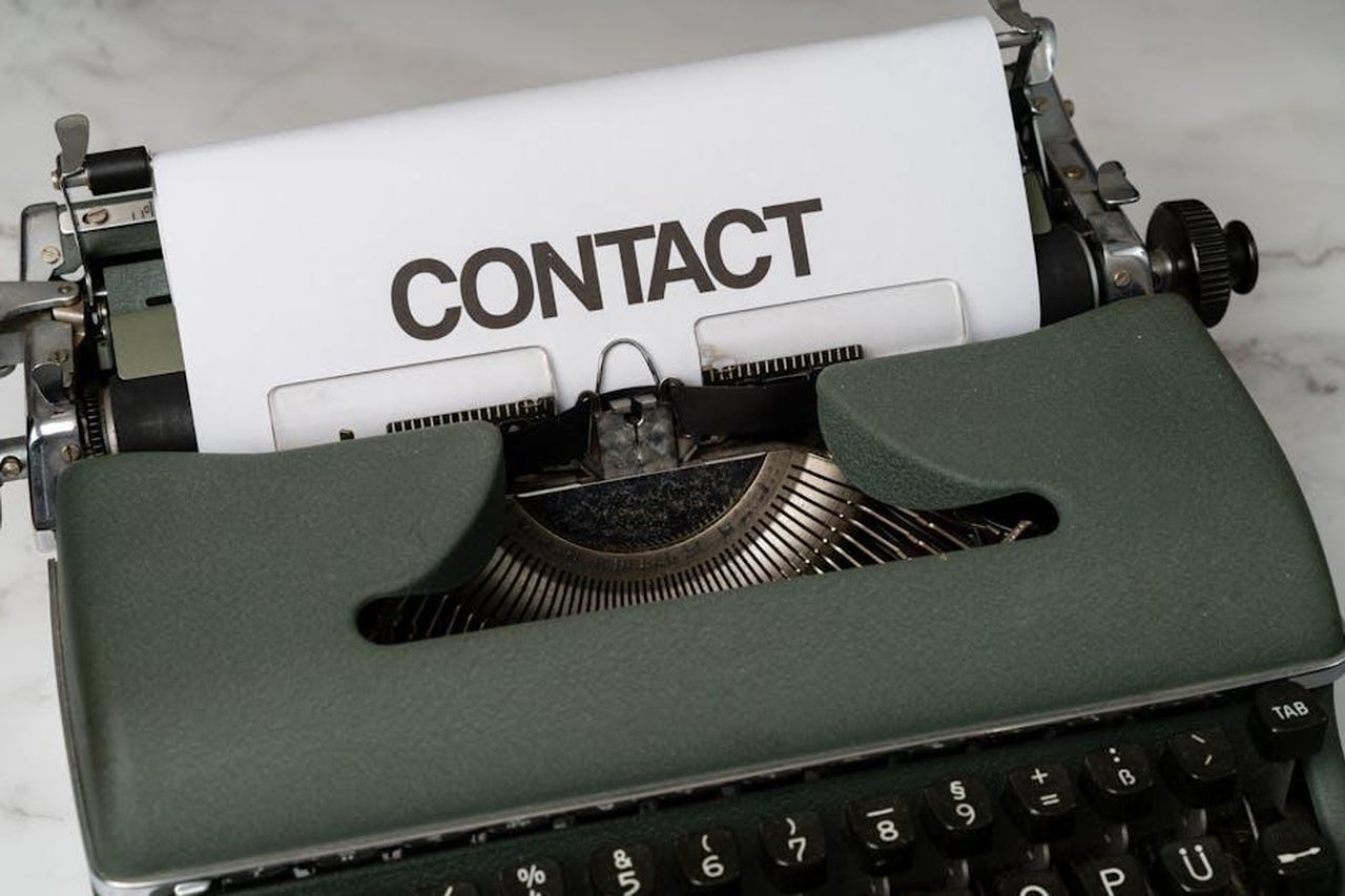 Contatti_stampa_3ZnJU1wXkF - Veicoli24 Source: Markus Winkler - pexels - Classic green typewriter with 'CONTACT' typed on paper, retro style.