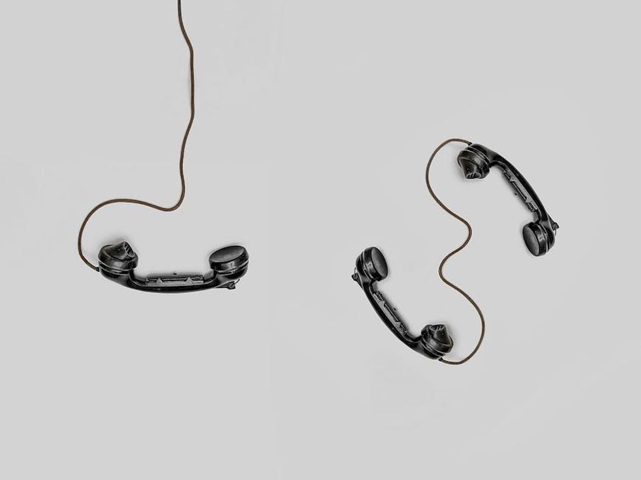 Contatto_Stampa_OxUsMH483a - Veicoli24 Source: Alex Andrews - pexels - Two vintage black telephone handsets connected by cords on gray background.