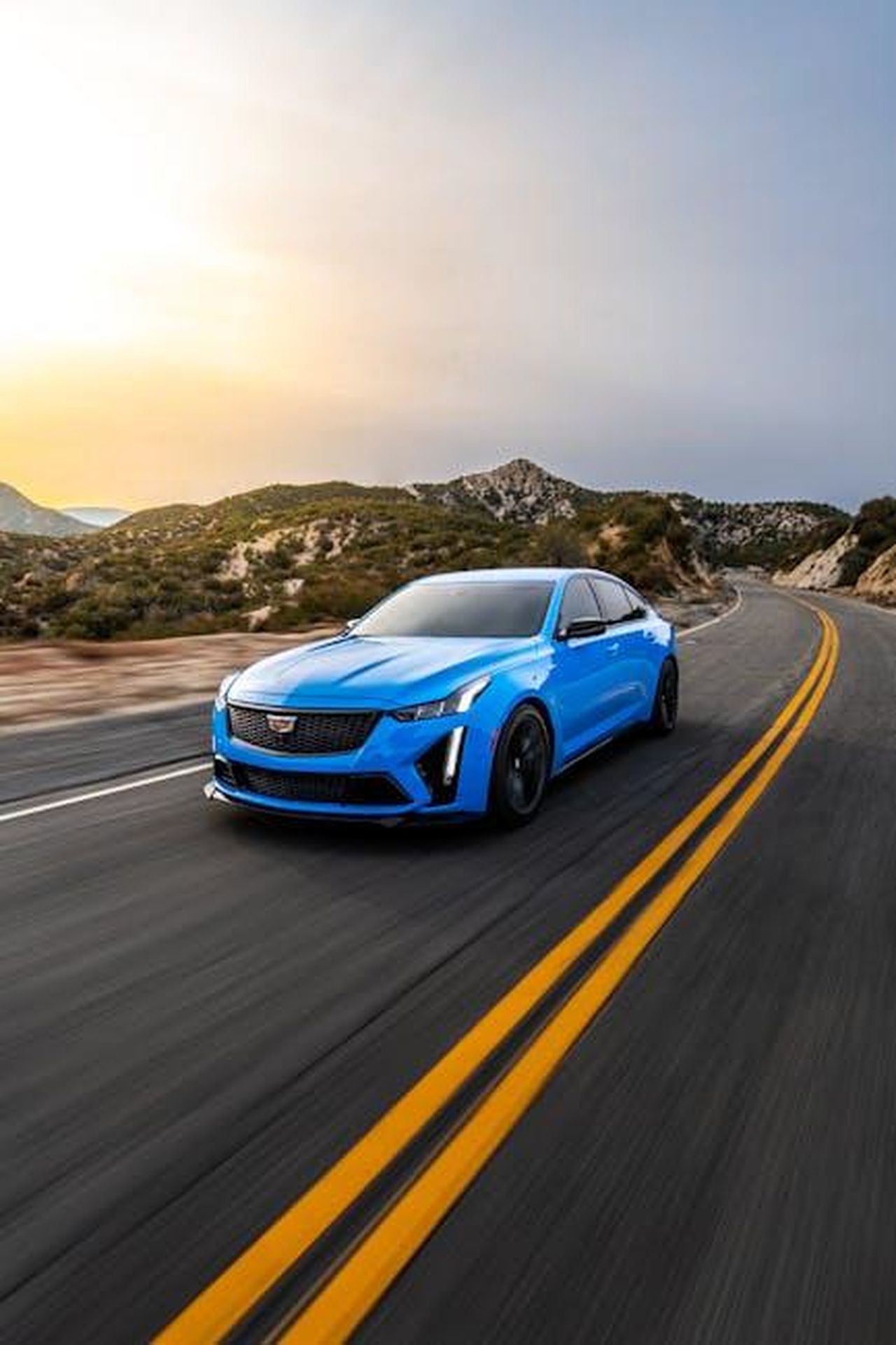Cosa_ci_piace_della_Cadillac_CT5_2025_gxnYVMU7kJ - Veicoli24 Source: Tyler Clemmensen - pexels - Blue sedan racing on a mountain highway during sunset in Los Angeles, California.