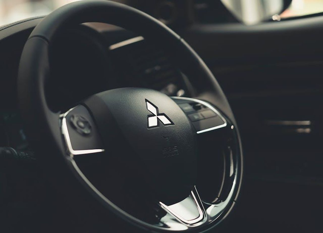 Cosa_ci_piace_della_Mitsubishi_Outlander_2025_swSgQKKnta - Veicoli24 Source: Asm Arif - pexels - Intricate details of a Mitsubishi steering wheel with a focus on texture and design.