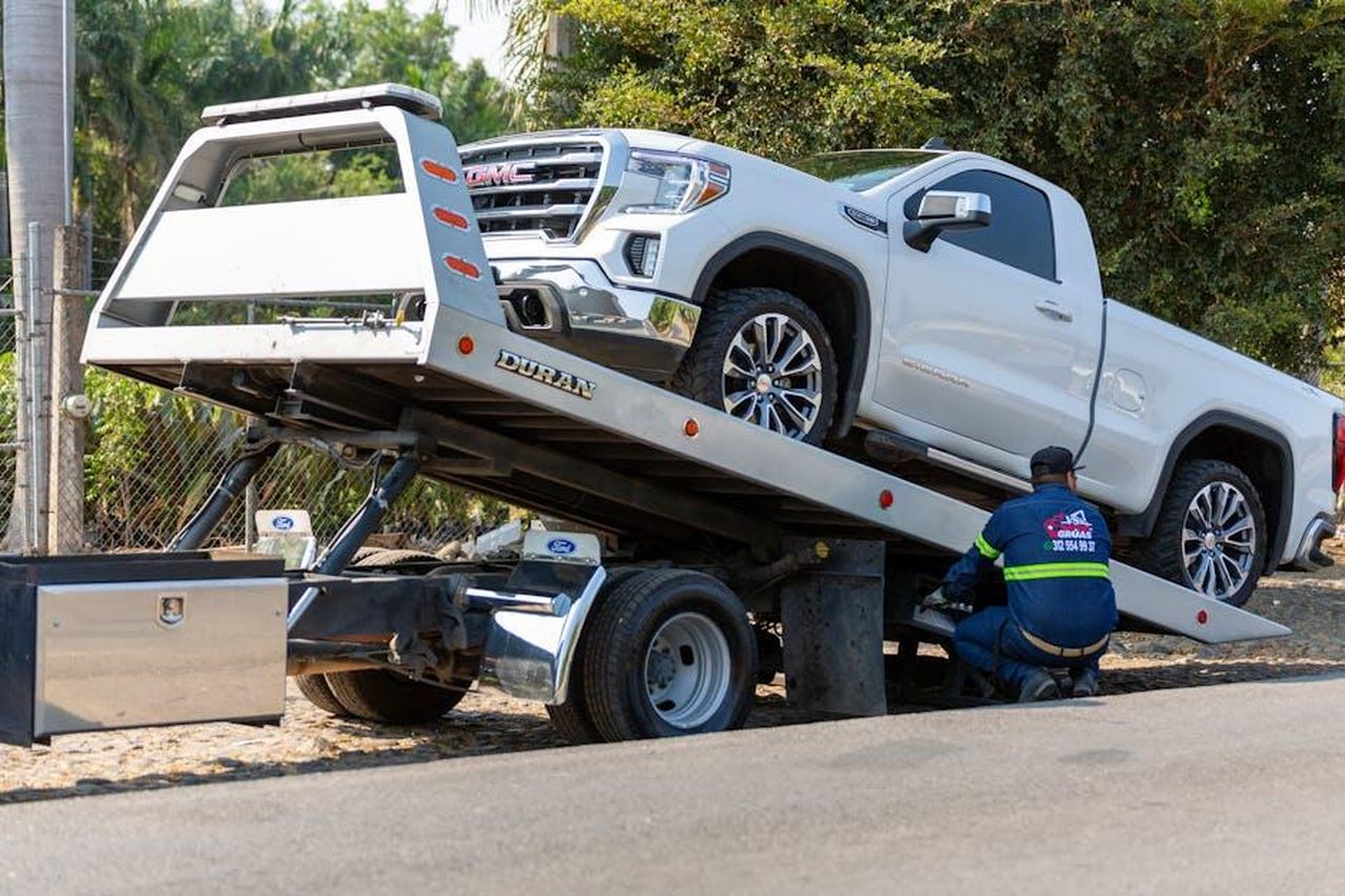 Cosa_non_ci_piace_del_GMC_Yukon_2025_sY6Mp1mGXP - Veicoli24 Source: Jonathan Reynaga - pexels - Tow truck operator loading white GMC pickup truck on street in daytime.