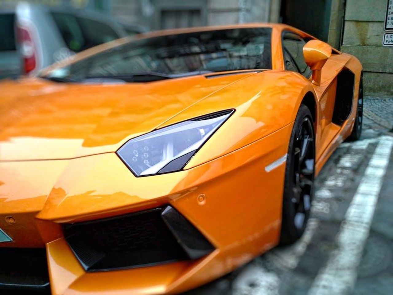 Cosa_non_ci_piace_nUaaBsPkQE - Veicoli24 Source: Pixabay - pexels - A striking orange luxury sports car parked on a city street in Brno, Czechia.