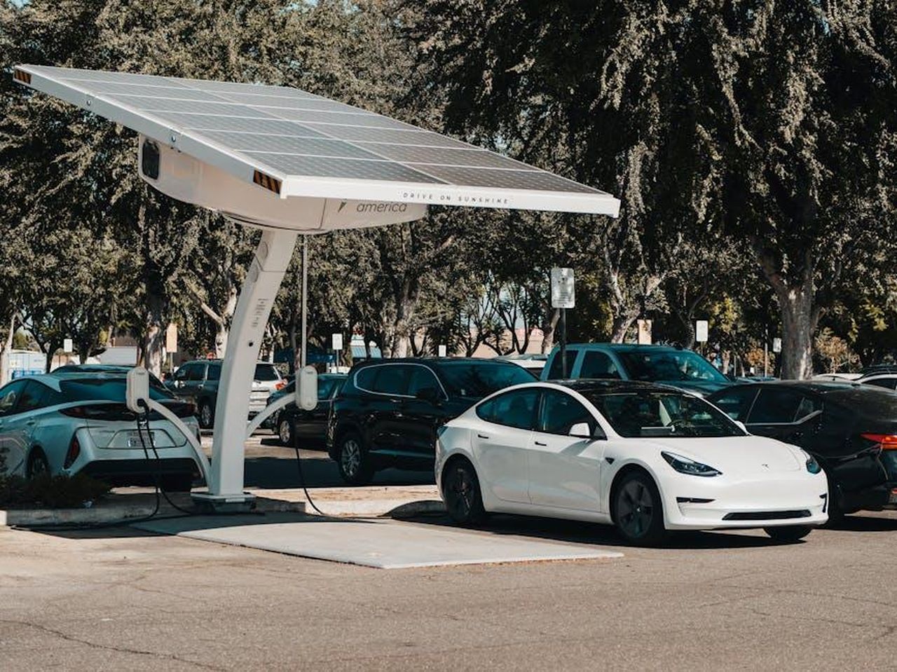 Crescita_dei_veicoli_elettrici_a_batteria_BEV_EcGBGvtCGv - Veicoli24 Source: Kindel Media - pexels - Electric car parked at a solar charging station outdoors, highlighting renewable energy and innovation.
