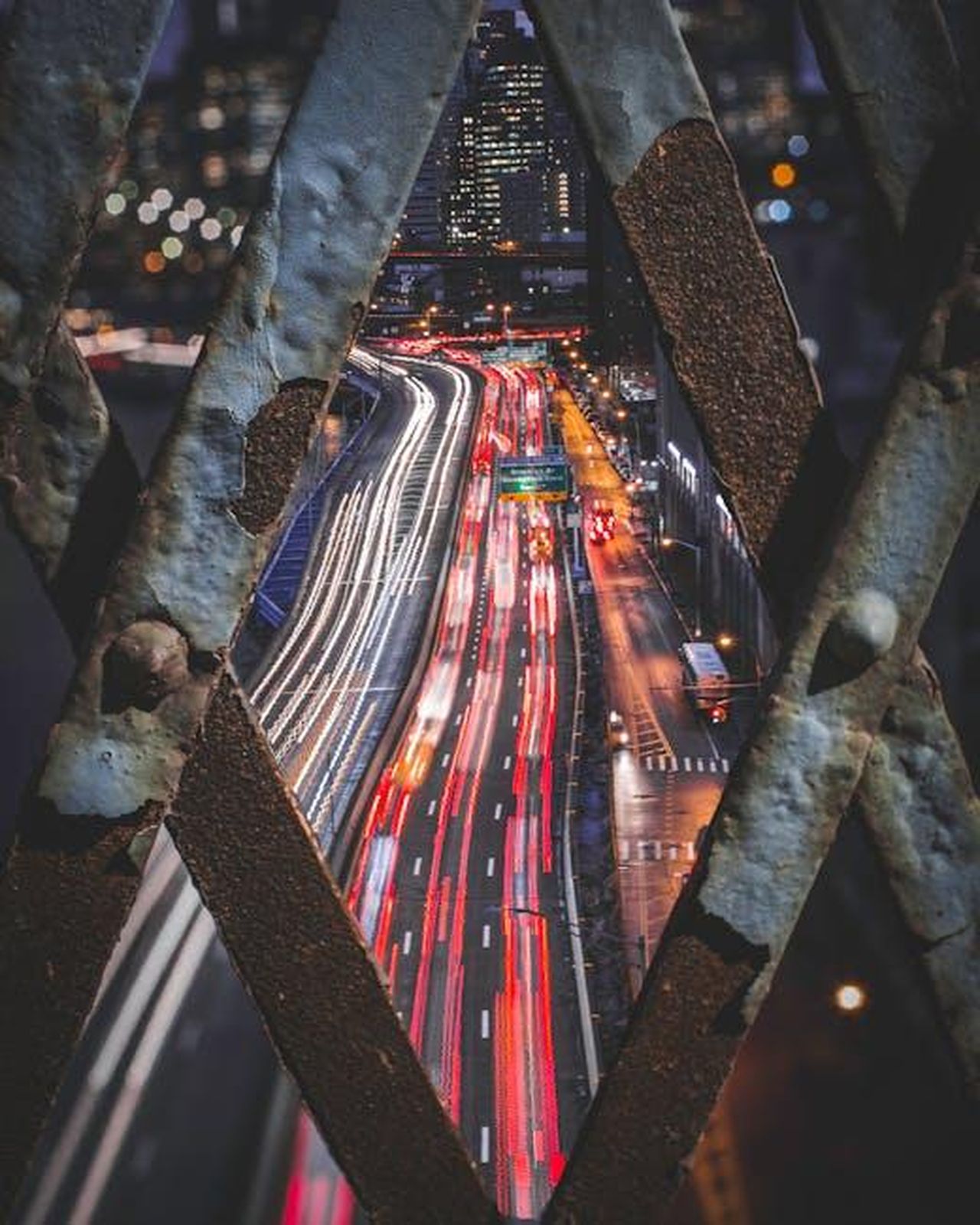 Crescita_della_domanda_di_veicoli_elettrici_usati_1ujrS00eRL - Veicoli24 Source: Jiarong Deng - pexels - Dynamic night photo of city traffic creating vibrant light trails through a lattice foreground.