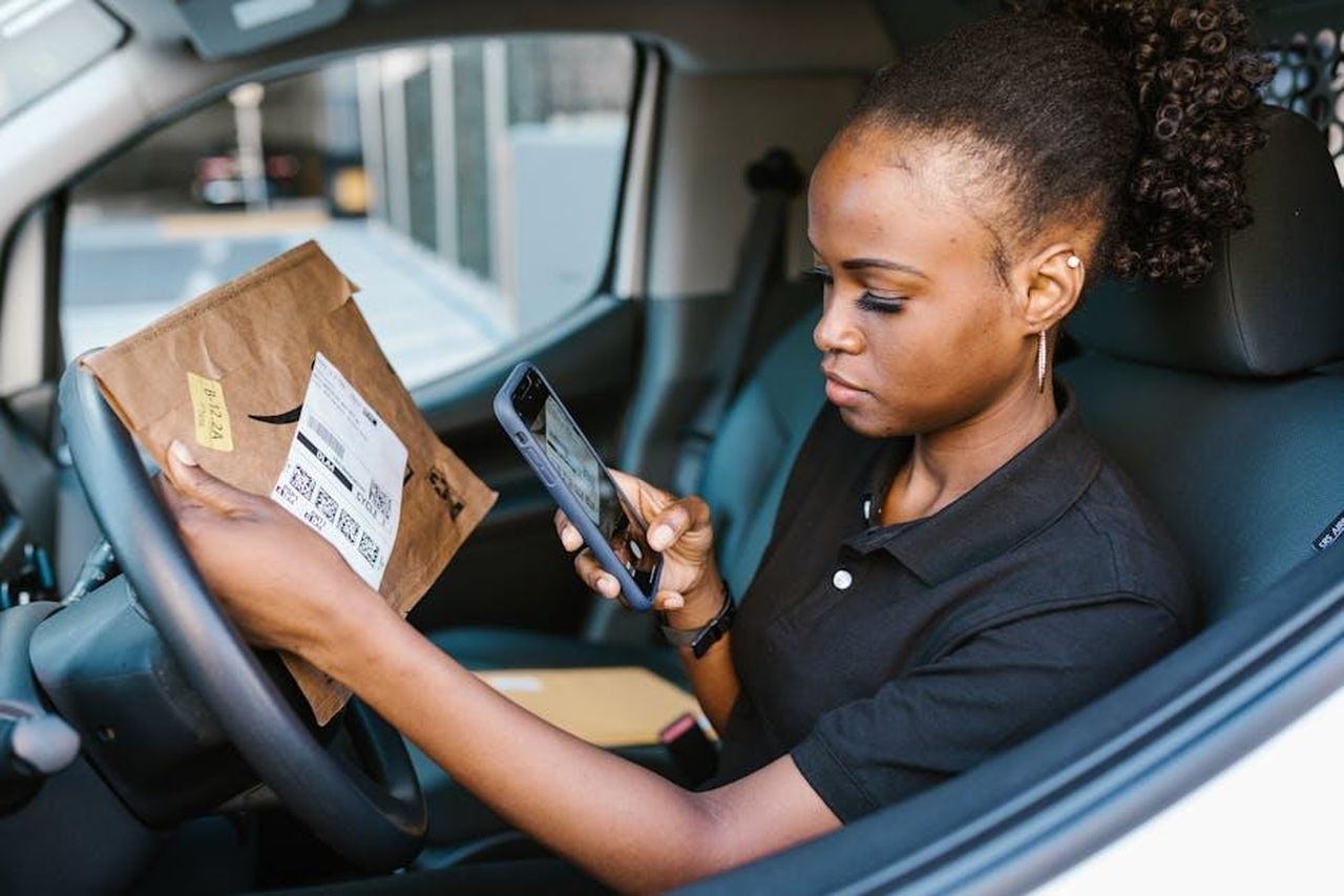 Da_startup_a_partner_logistico_del_BMW_Group_la_storia_di_successo_di_Embotech_tGqp7kwB4F - Veicoli24 Source: RDNE Stock project - pexels - A delivery woman scans a package using her smartphone inside a vehicle.