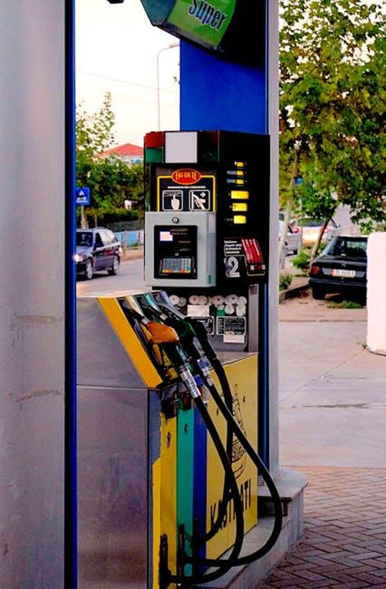 Declino_delle_vendite_di_veicoli_a_benzina_e_diesel_hU0wfWhGRf - Veicoli24 Source: Ingo Joseph - pexels - Fuel pumps at a modern gas station on an urban street, with vehicles and trees visible.