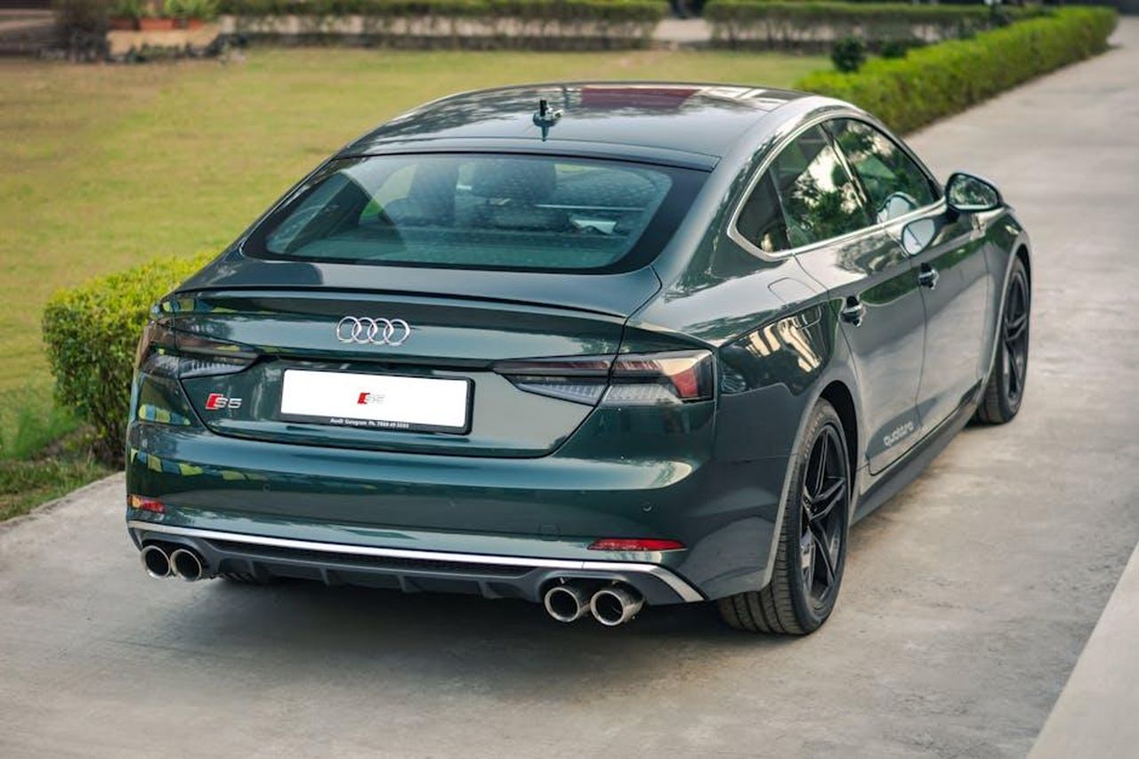 Dettagli_sul_nuovo_Audi_S5_uHAFYGDlvL - Veicoli24 Source: Ishan Kulshrestha - pexels - High-angle view of a parked Audi car showcasing sleek design and back view aesthetics.