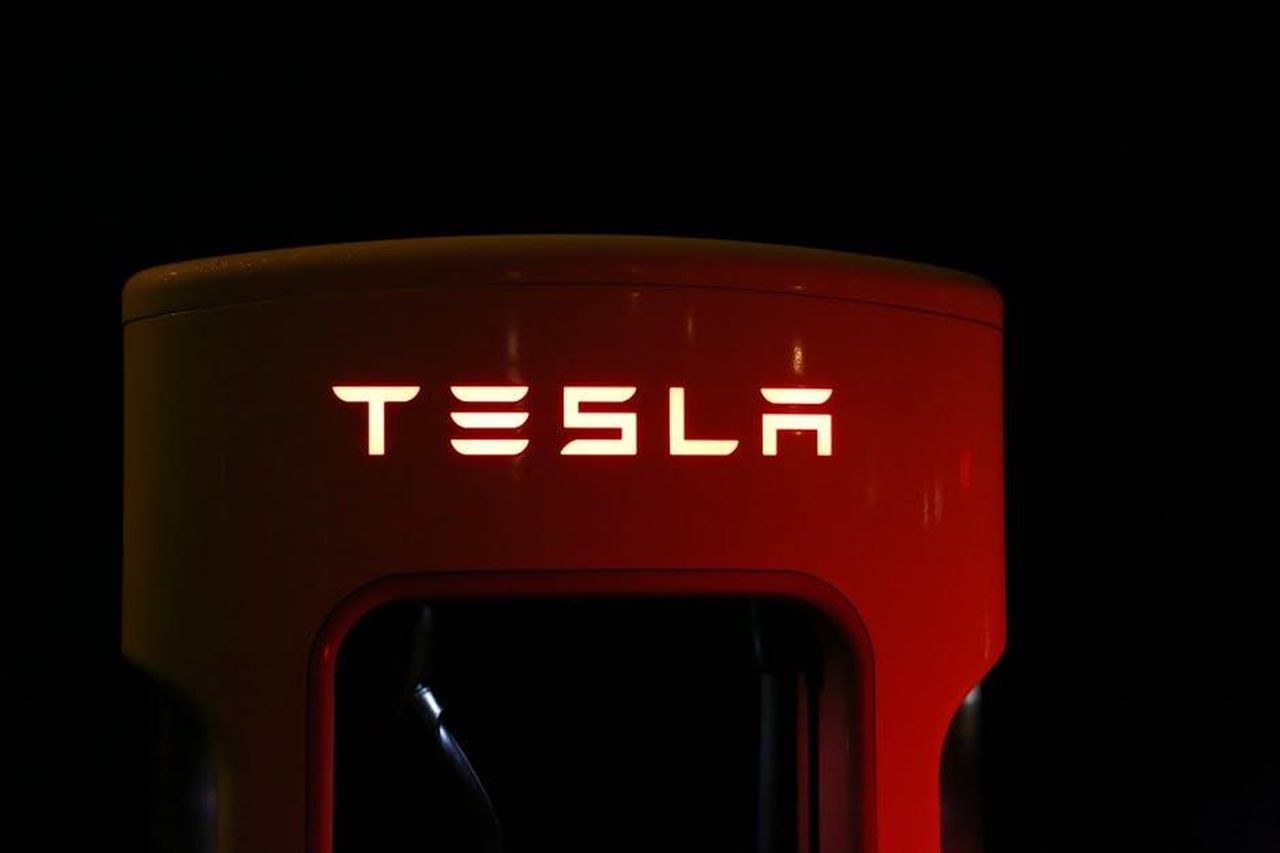 Dettagli_tecnici_del_Kia_EV3_GT_ieidE3mrWW - Veicoli24 Source: Pixabay - pexels - Close-up of a Tesla charging station illuminated at night, showcasing modern automotive technology.