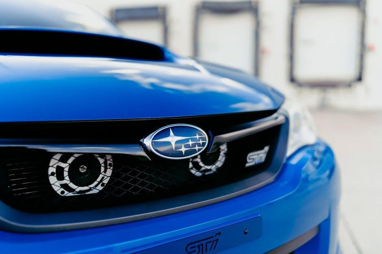 Dove_viene_prodotta_la_Subaru_Ascent_2025_8Nzuyhx1Vl - Veicoli24 Source: Garvin St. Villier - pexels - A detailed view of a blue Subaru car grille showcasing its logo and design elements.