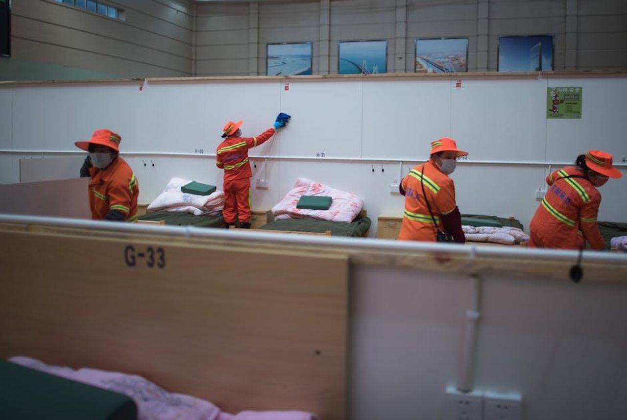 Doveri_del_Professionista_Sanitario_VqKcM5FLpk - Veicoli24 Source: Greece-China News - pexels - Hospital staff in orange uniforms organize and clean patient beds in a healthcare facility.