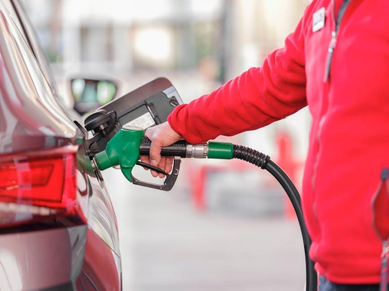 Economia_di_carburante_del_GMC_Yukon_2025_PY4WsBK1qe - Veicoli24 Source: Engin Akyurt - pexels - Close-up of a person refueling a car with a green hose at a gas station.