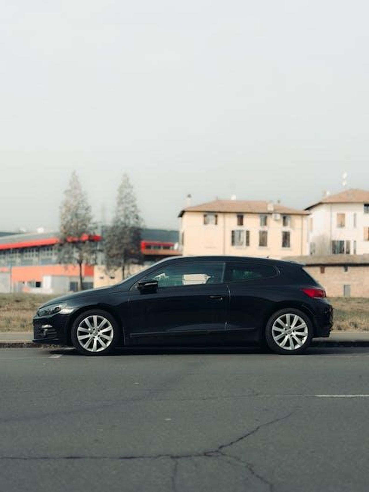 Efficienza_e_design_della_Toyota_Sienna_IGxb2bOZc6 - Veicoli24 Source: Borta - pexels - Black hatchback car parked along an urban Europe street with buildings in background.