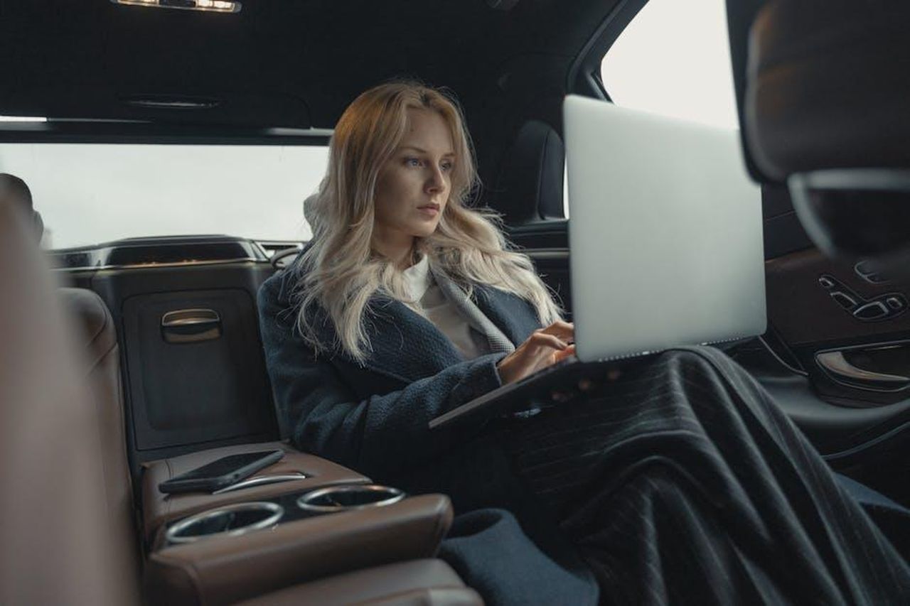 Espansione_delle_offerte_di_Targa_Telematics_8FWCB96bQi - Veicoli24 Source: Tima Miroshnichenko - pexels - Businesswoman working on her laptop in the back seat of a luxury car.
