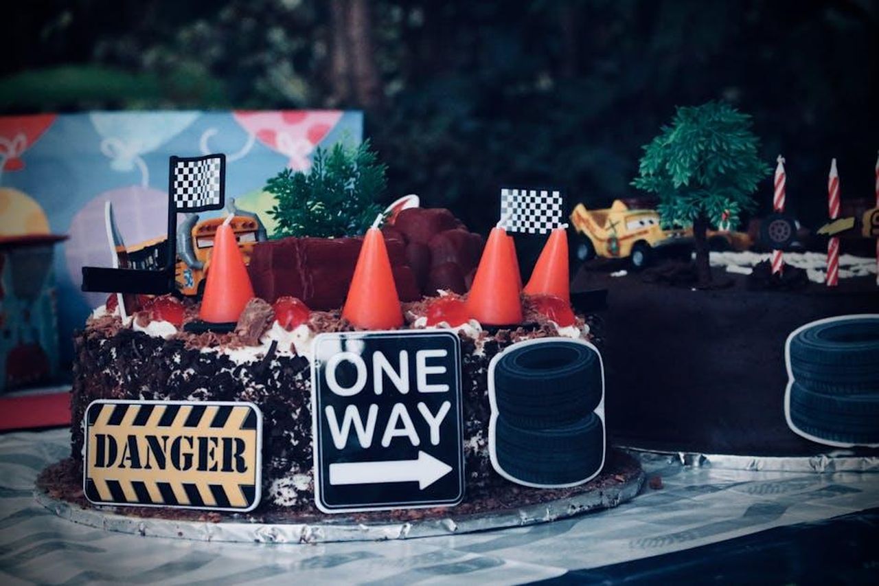 Eventi_principali_supportati_da_JBR_Capital_XtIgHyGR0t - Veicoli24 Source: Edgar Okioga - pexels - Fun race car themed birthday cake featuring toy cars and signs. Perfect for celebrations.