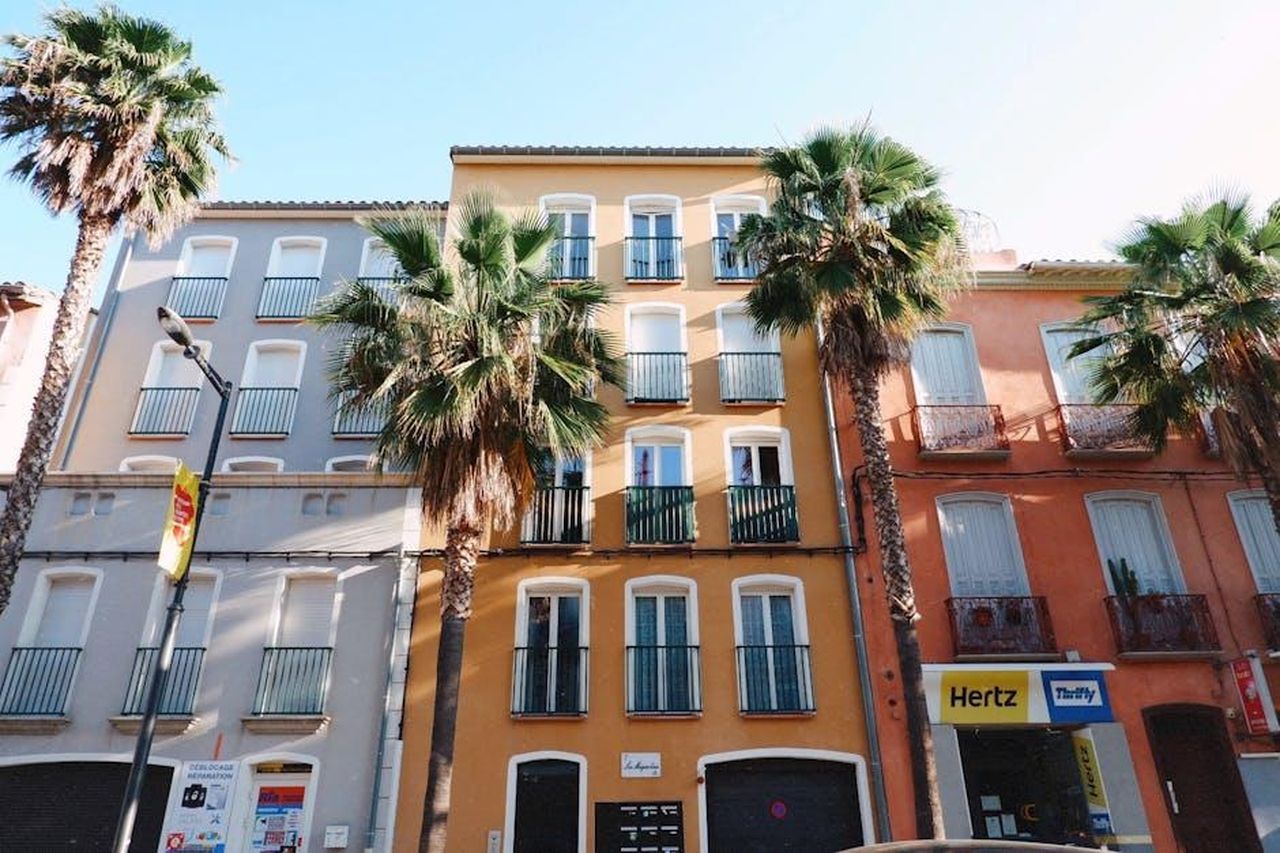 Evoluzione_del_servizio_di_noleggio_cbHpiXo0xC - Veicoli24 Source: Joanne Adela - pexels - Vibrant apartment buildings with palm trees lining a sunny street exterior, perfect for travel and urban themes.
