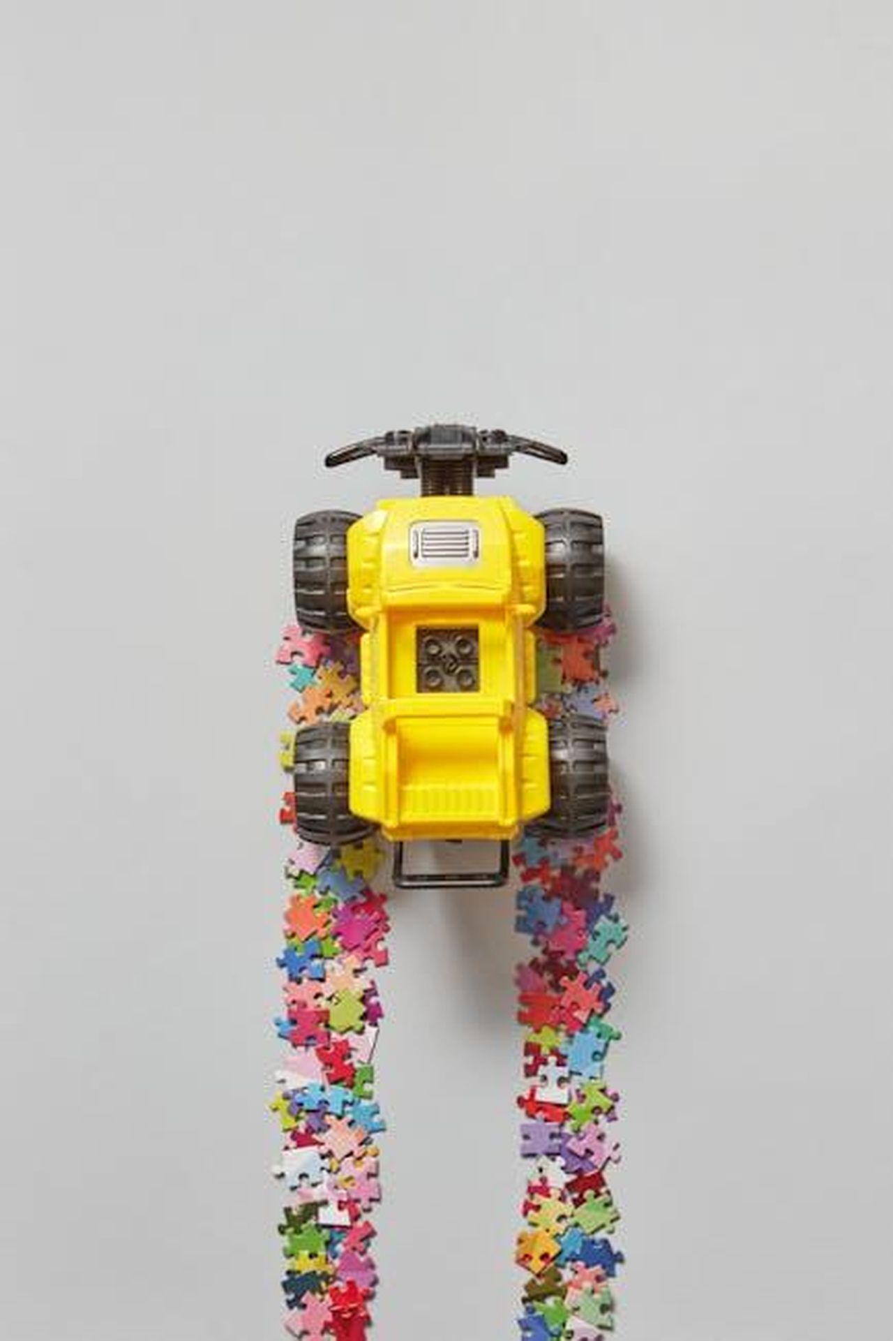 Fondo_di_Sviluppo_del_Presidente_per_i_Club_Membri_aeDybPUH6n - Veicoli24 Source: DS stories - pexels - A vibrant yellow toy truck on a gray background with colorful jigsaw puzzle trail, offering ample copy space.