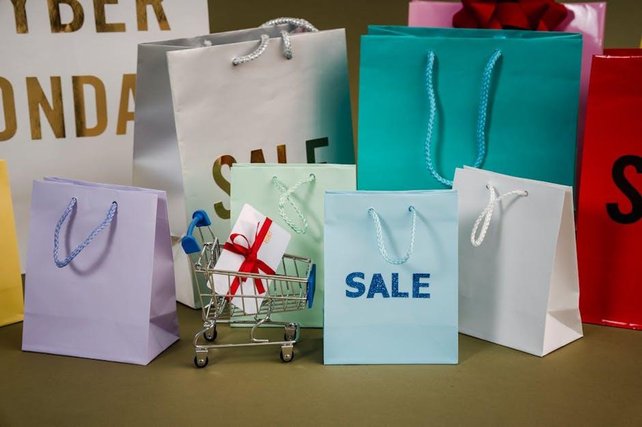 Futuri_sviluppi_e_modelli_XAhge2N6xf - Veicoli24 Source: Sora Shimazaki - pexels - A mix of colorful shopping bags and a small cart displaying a discount gift.