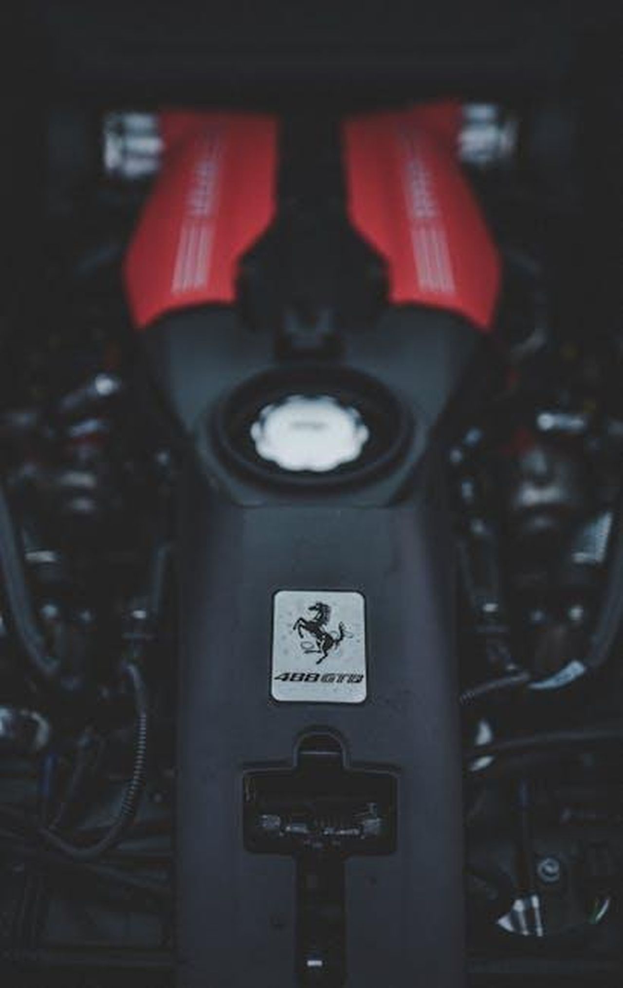 Futuro_dei_motori_V8_e_ibridi_rFxmkNUo5S - Veicoli24 Source: Zachary DeBottis - pexels - Focused view of a red Ferrari engine showcasing automotive engineering and power.