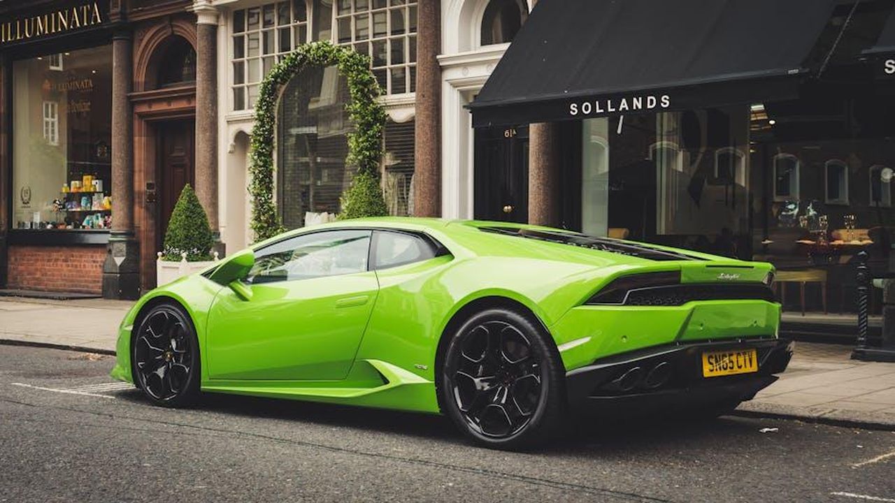 Il_futuro_della_produzione_T50_e_oltre_SJOM3aSgxw - Veicoli24 Source: Adrian Dorobantu - pexels - A vibrant lime green Lamborghini parked on a London street, showcasing luxury and style.